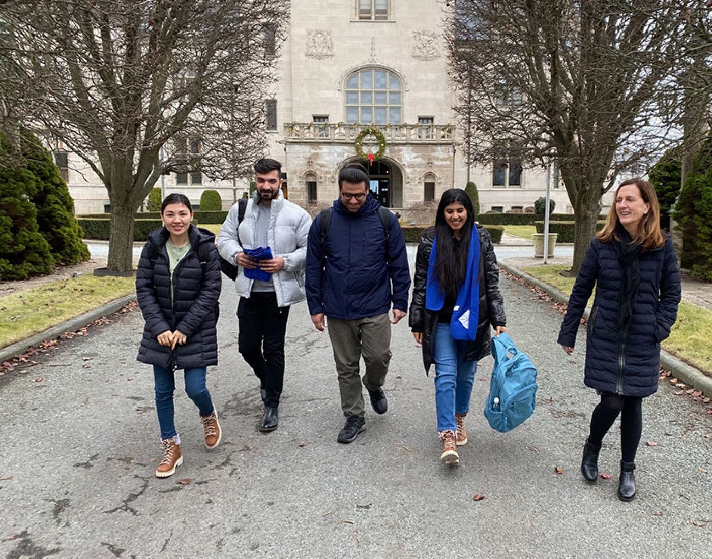 Group of people walking down a driveway.