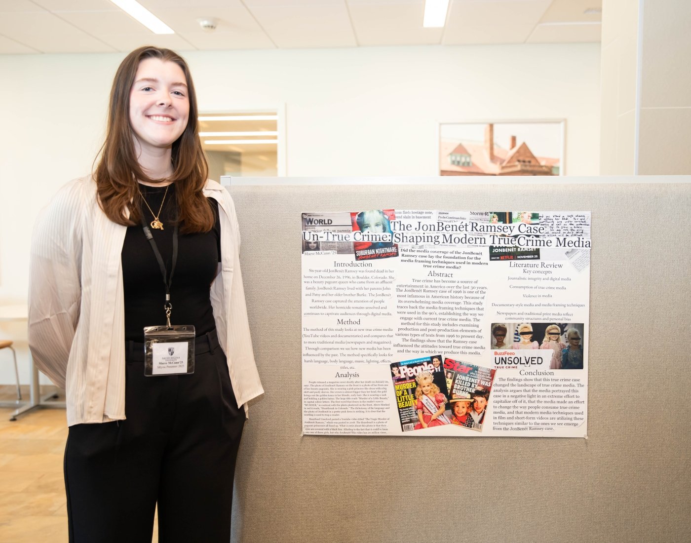 student standing near poster presentation on media
