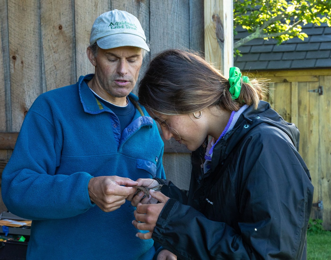 student and professor studying bird