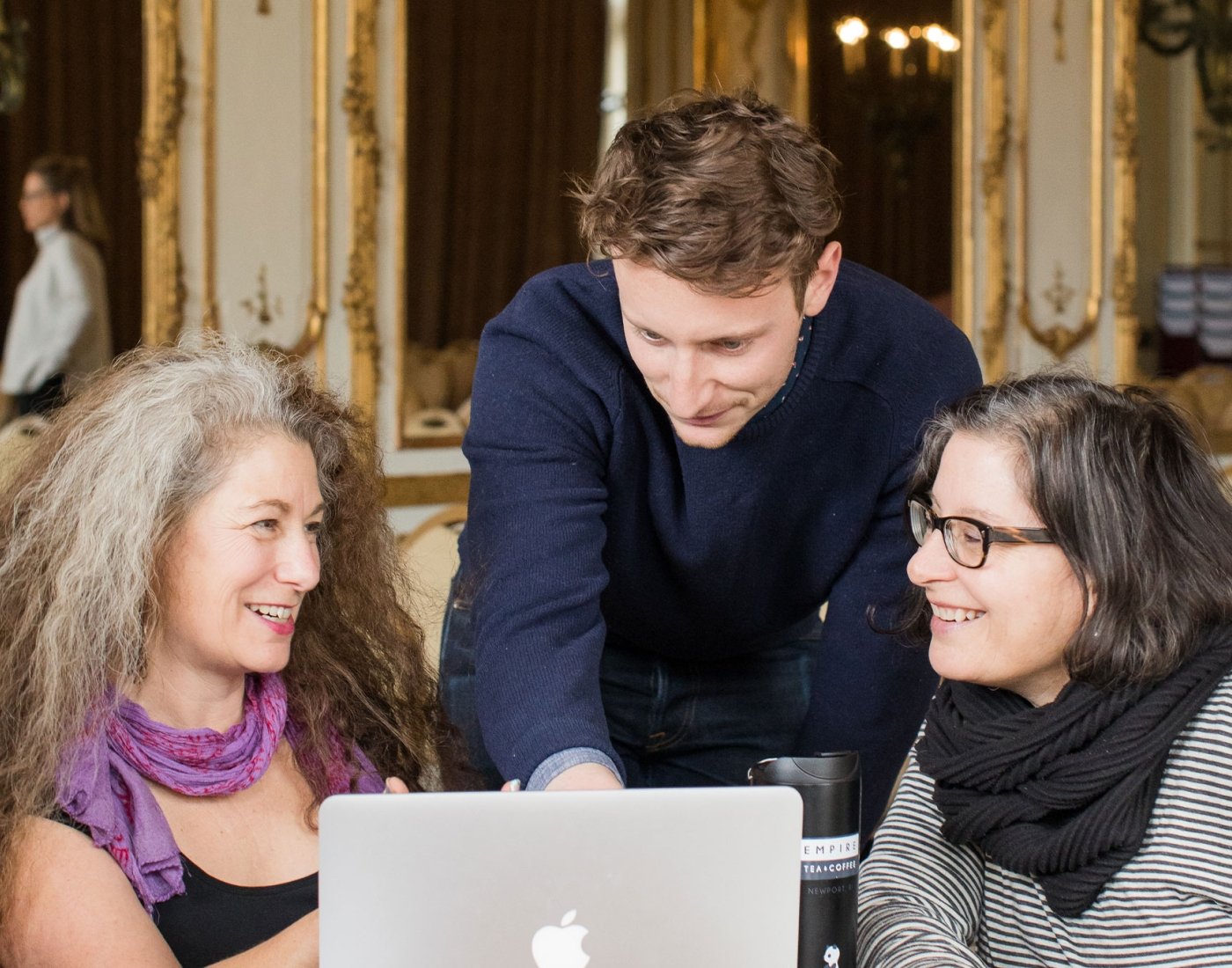 three people talking over laptop
