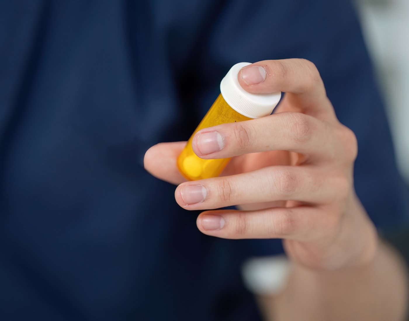 student with pill bottle