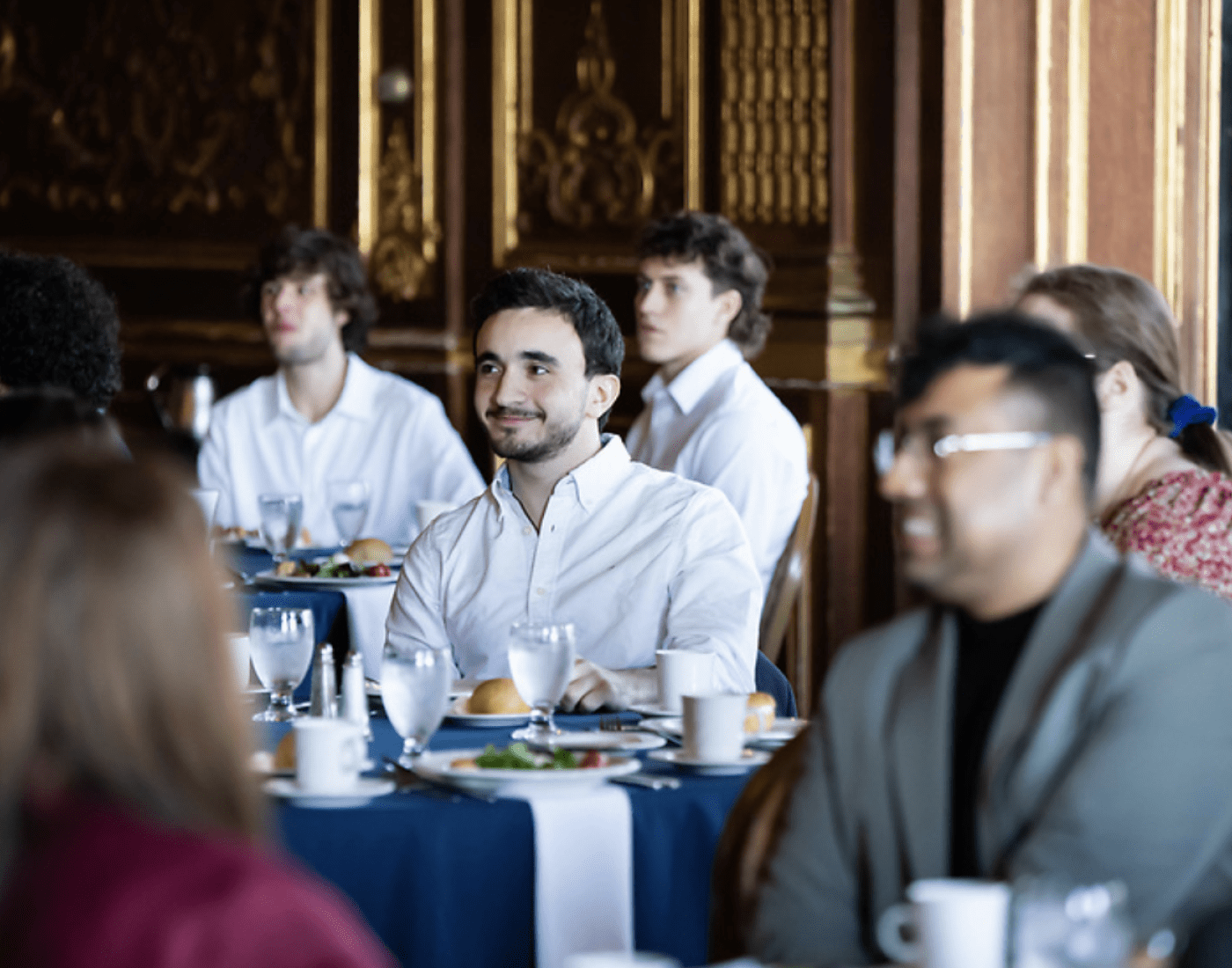 Students in business attire in a conference dining room