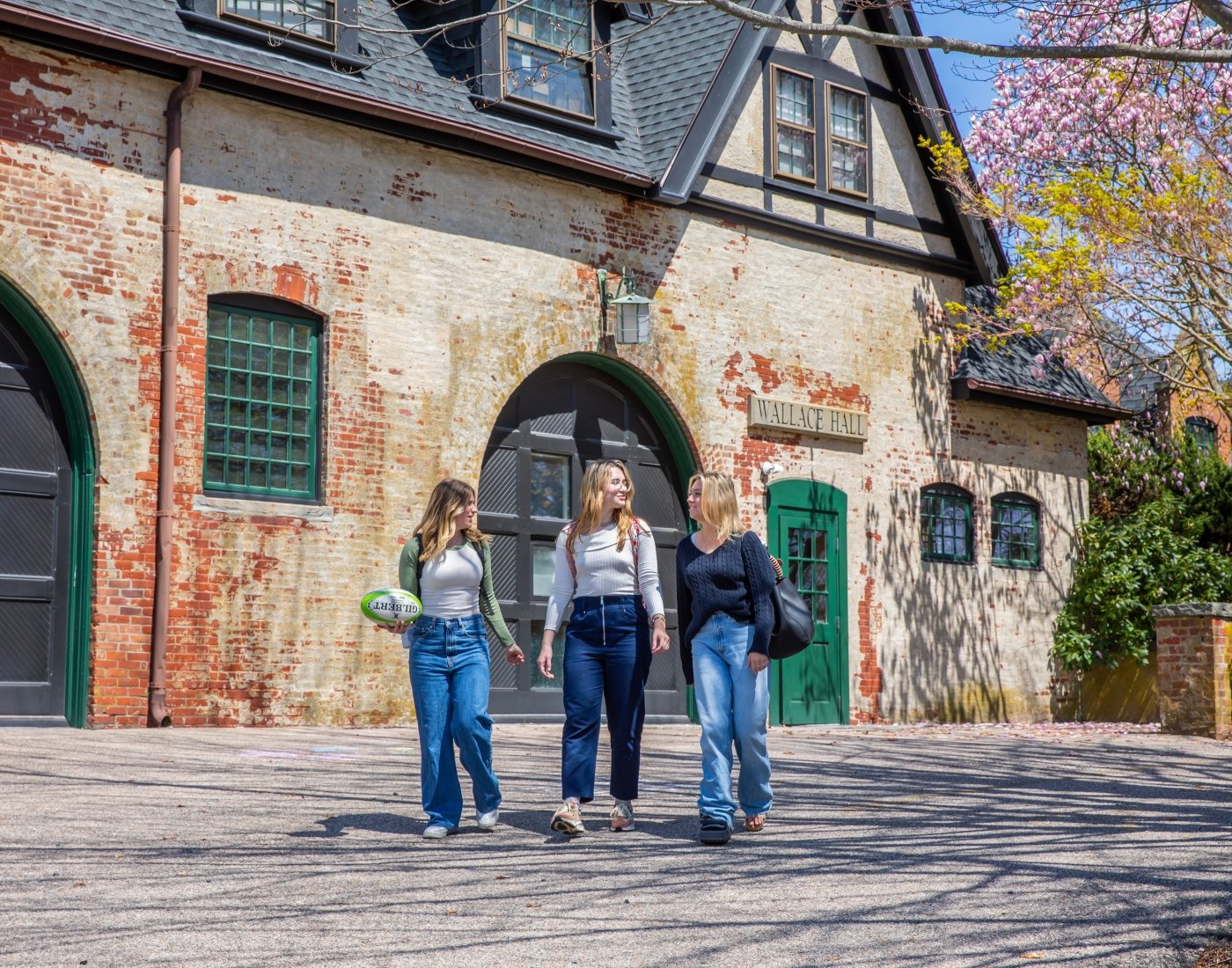 Students walk outside Salve Regina University's Wallace Hall