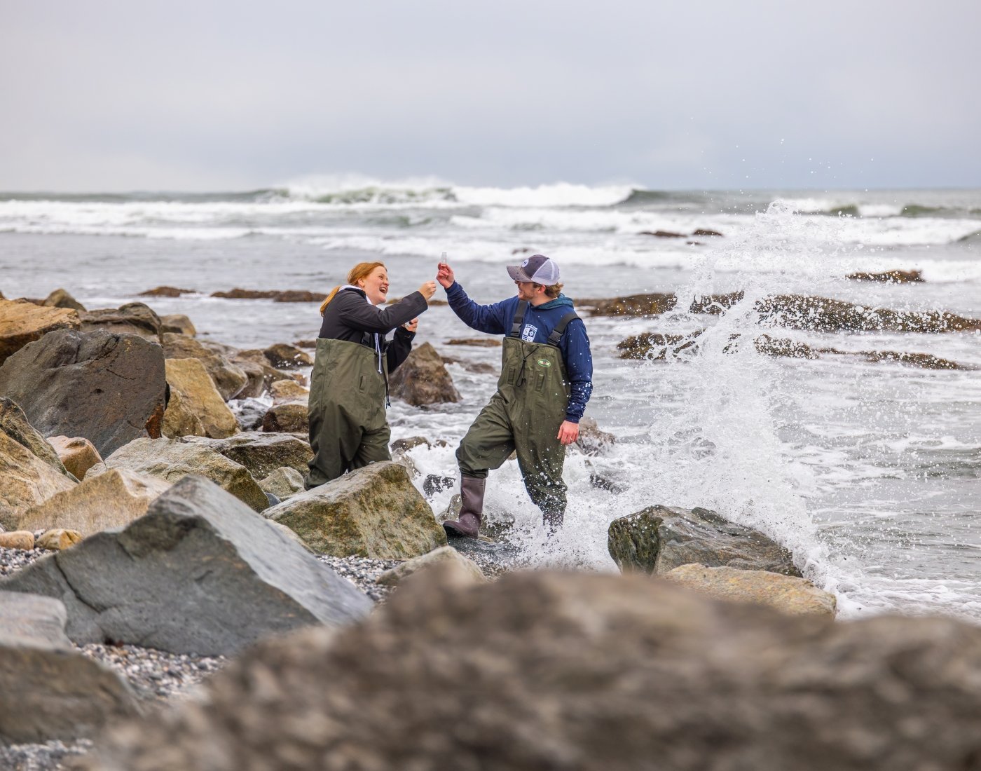Students collect water samples along the coastline.