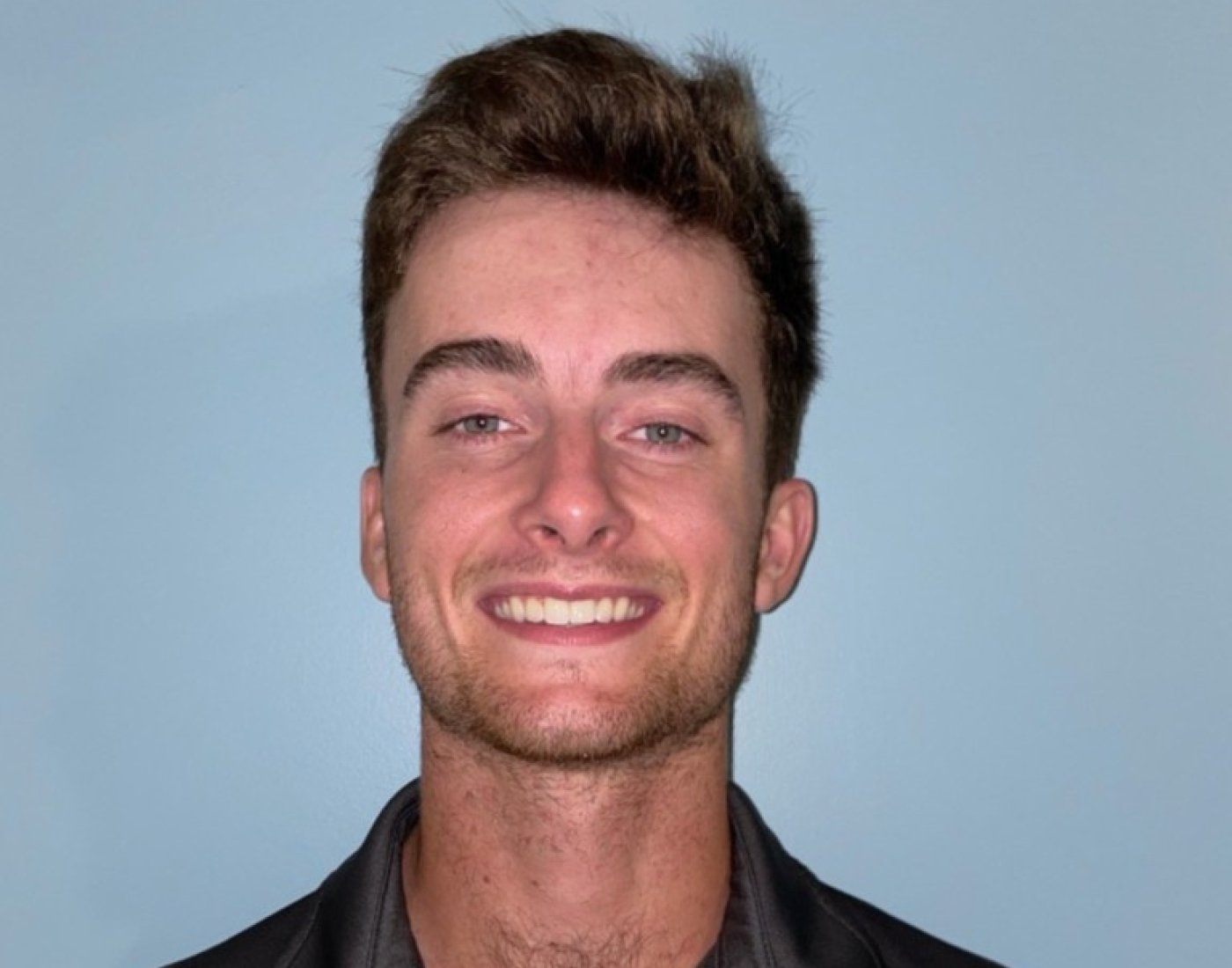 Headshot of Ferrari against blue backdrop.
