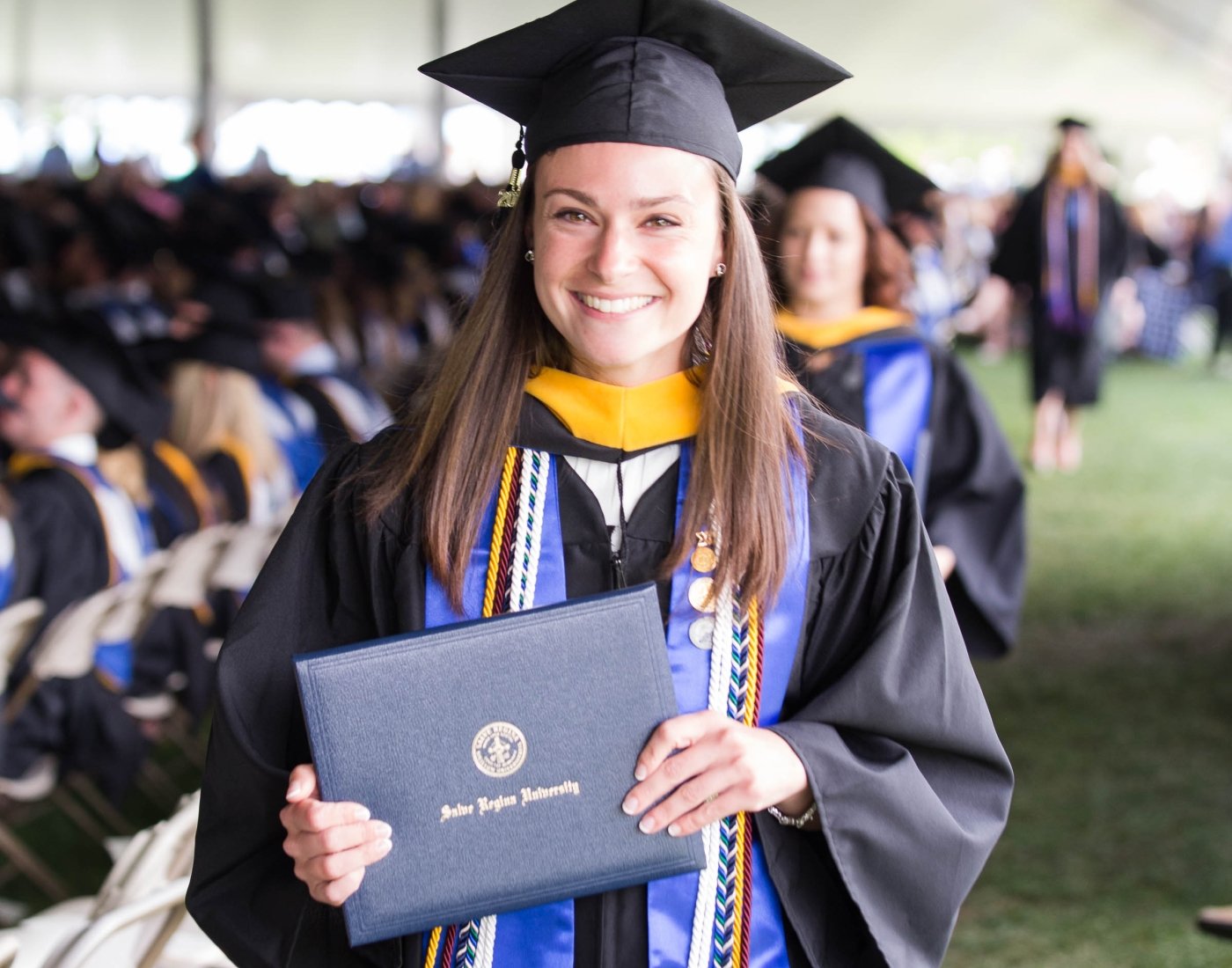 Graduate holding her Salve Regina diploma
