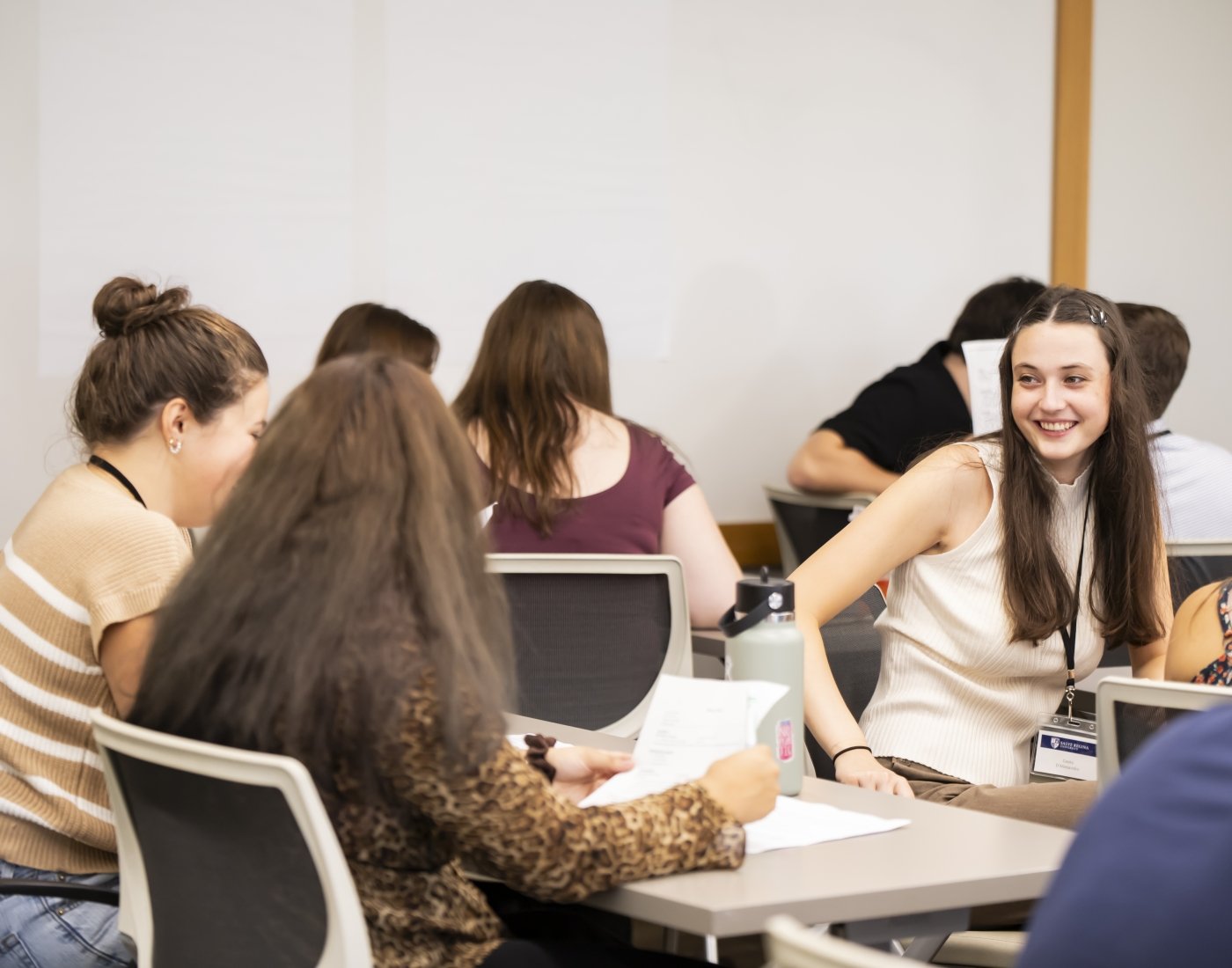Students seated at desks in classroom with papers