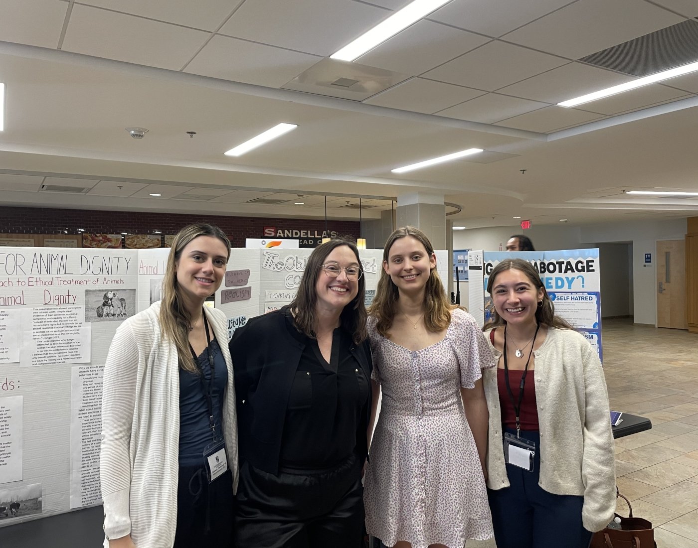 Group photo of students and professor in front of posterboard.