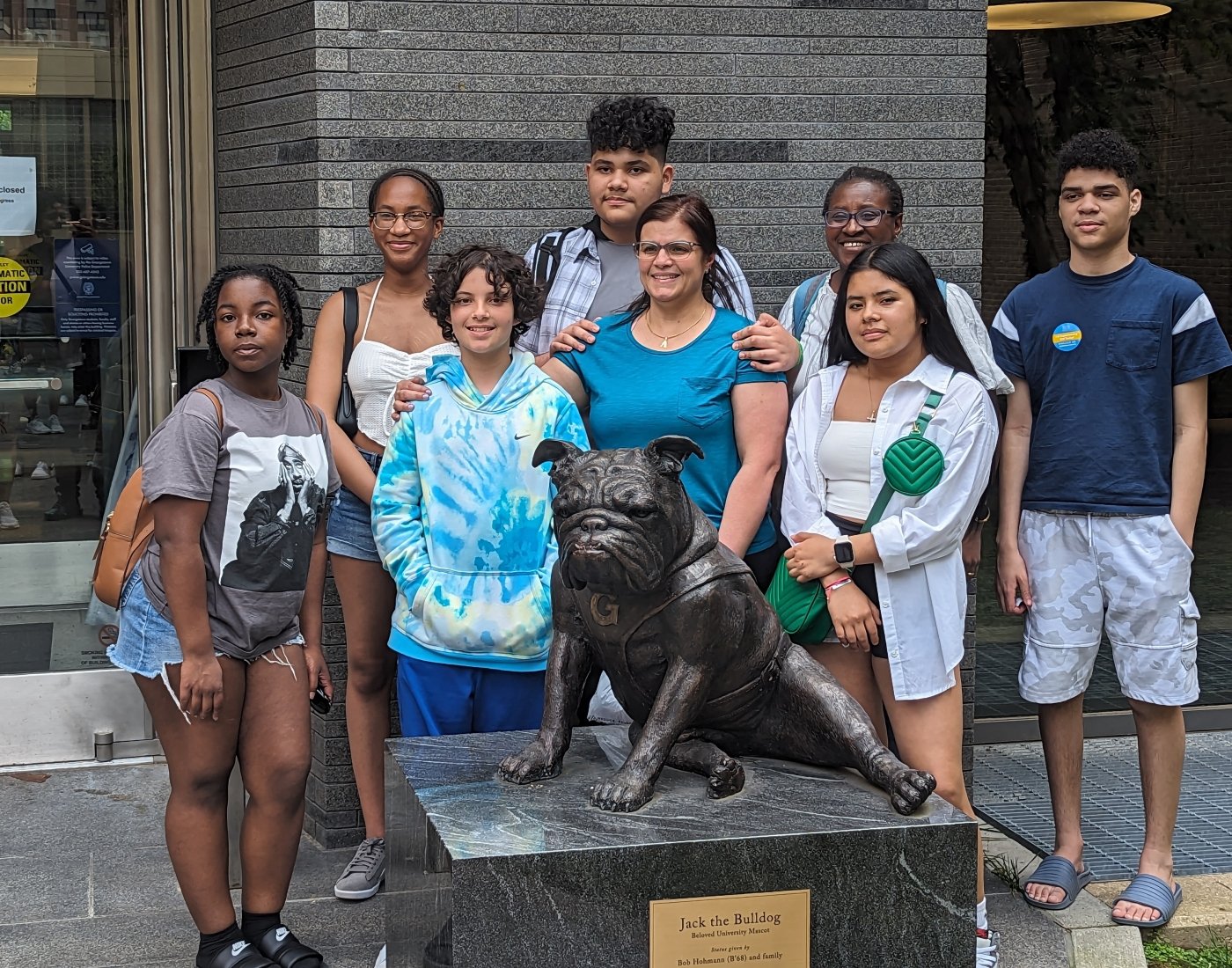 A group of people standing next to a statue of a bulldog