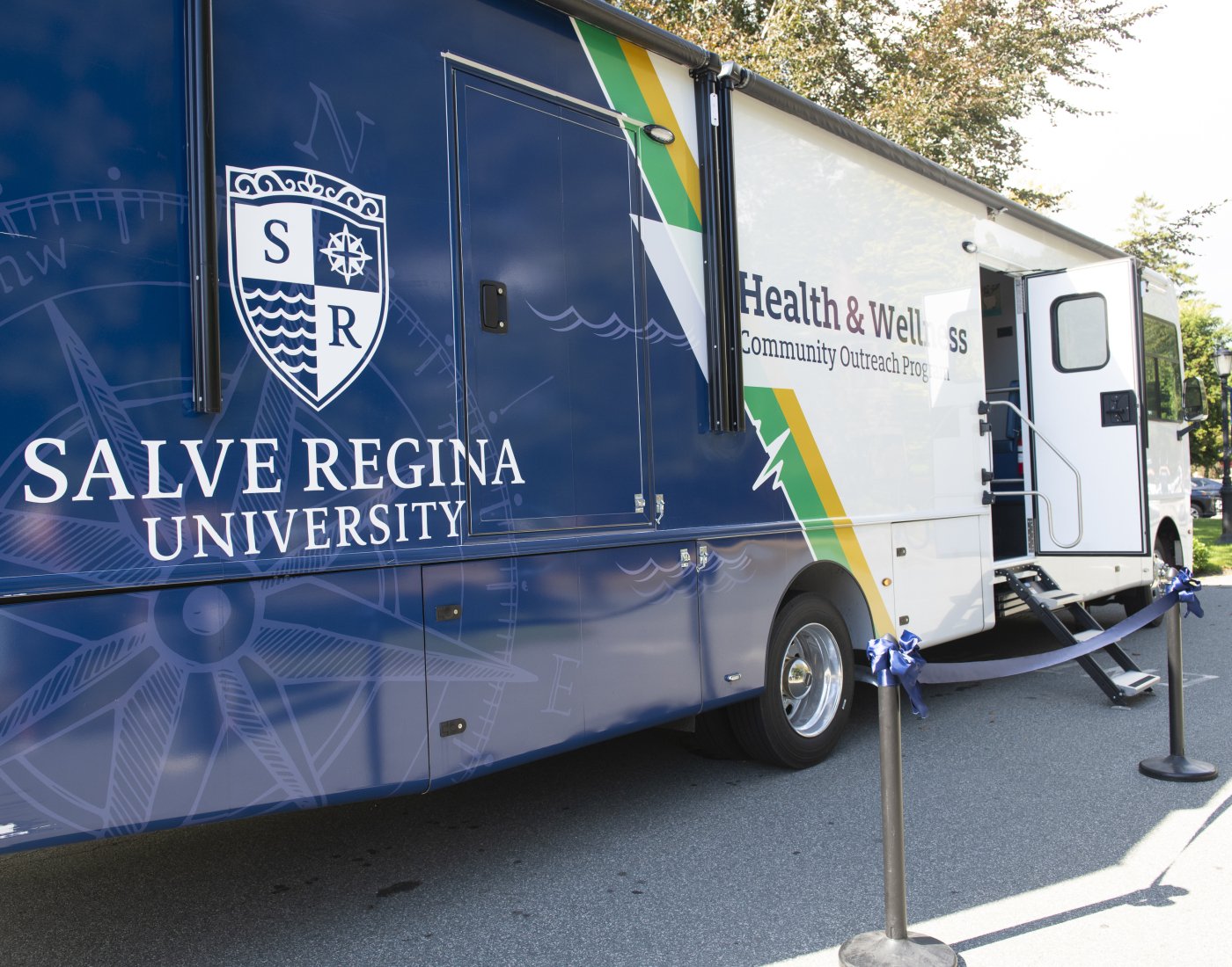 A large blue and white van branded with the Salve Regina University logo is parked outdoors.