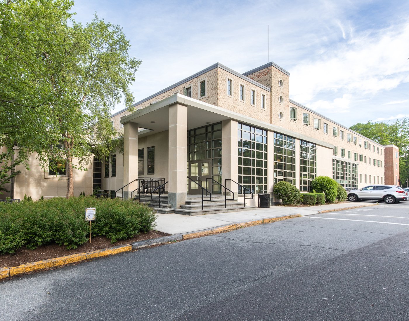 A large square building with a wall of windows on one side