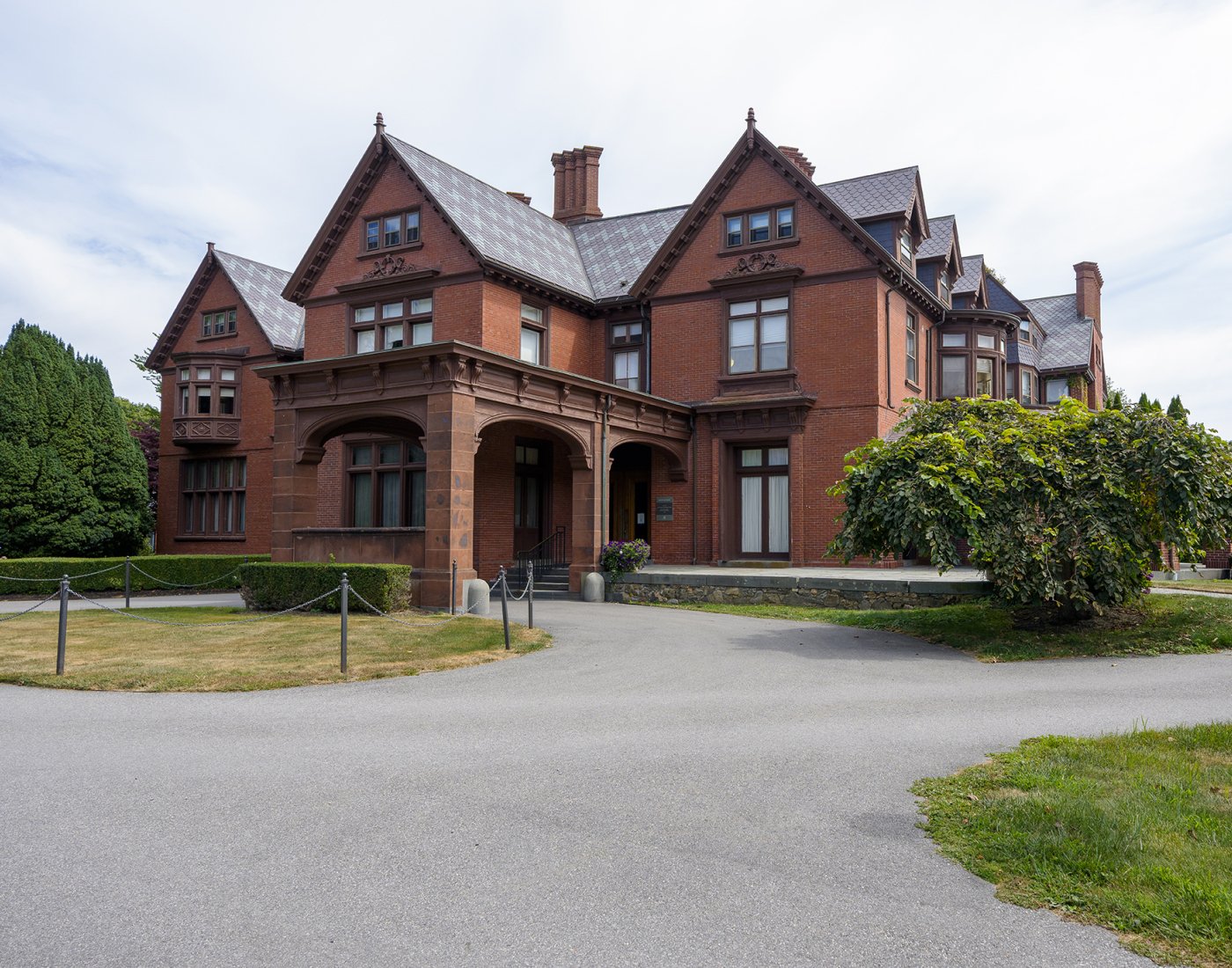 A historic stone building with a wide driveway in the front.