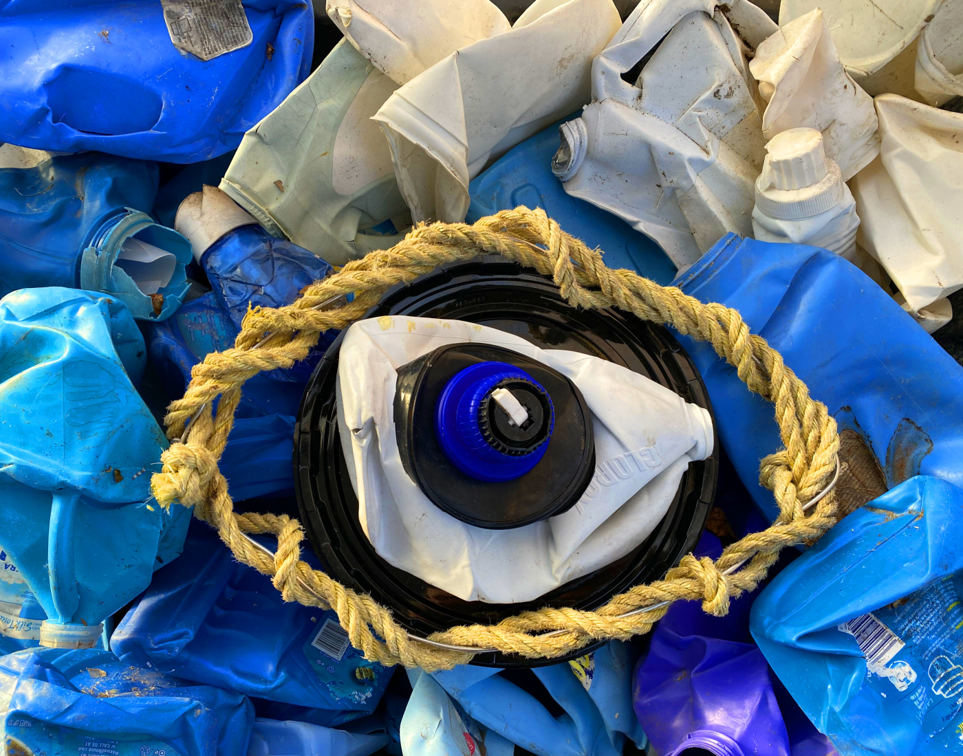An art piece made from recyclables that features a large eye in the center.