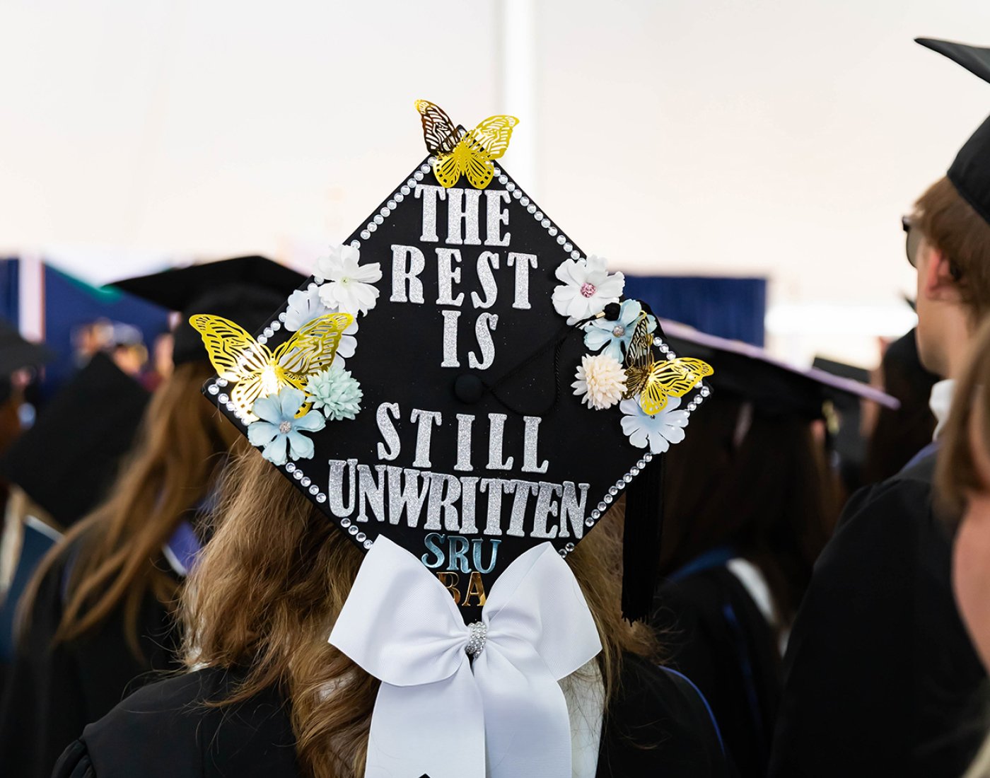 A graduation cap decorated with the words "The rest is still unwritten."