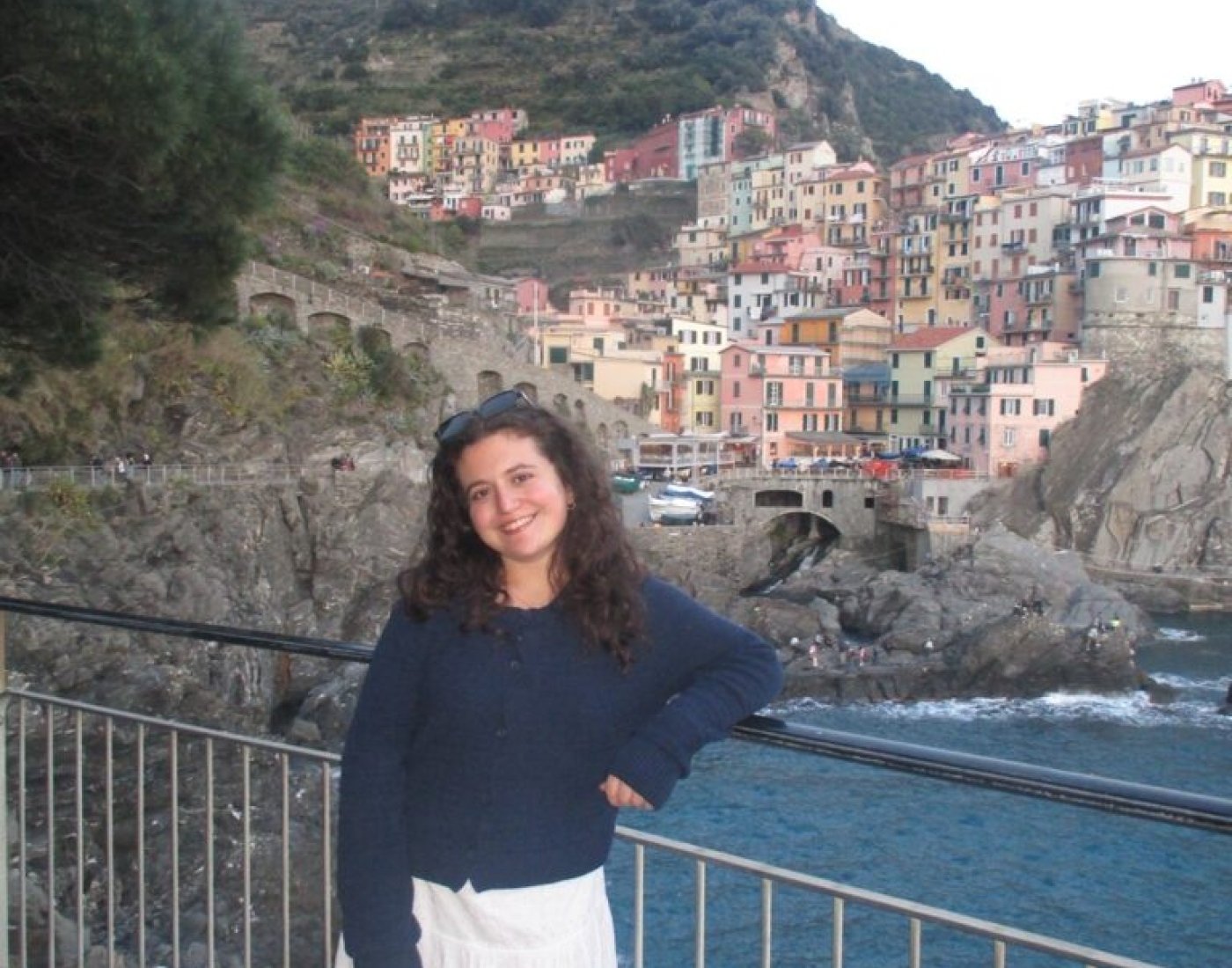 Female student leaning on a fence rail in front of hills of Rome