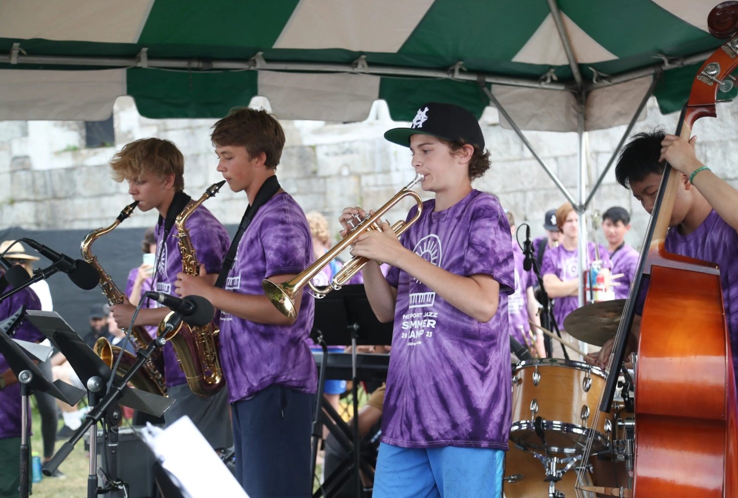 students in purple tie dye shirts playing jazz instruments at the Newport Jazz Festival