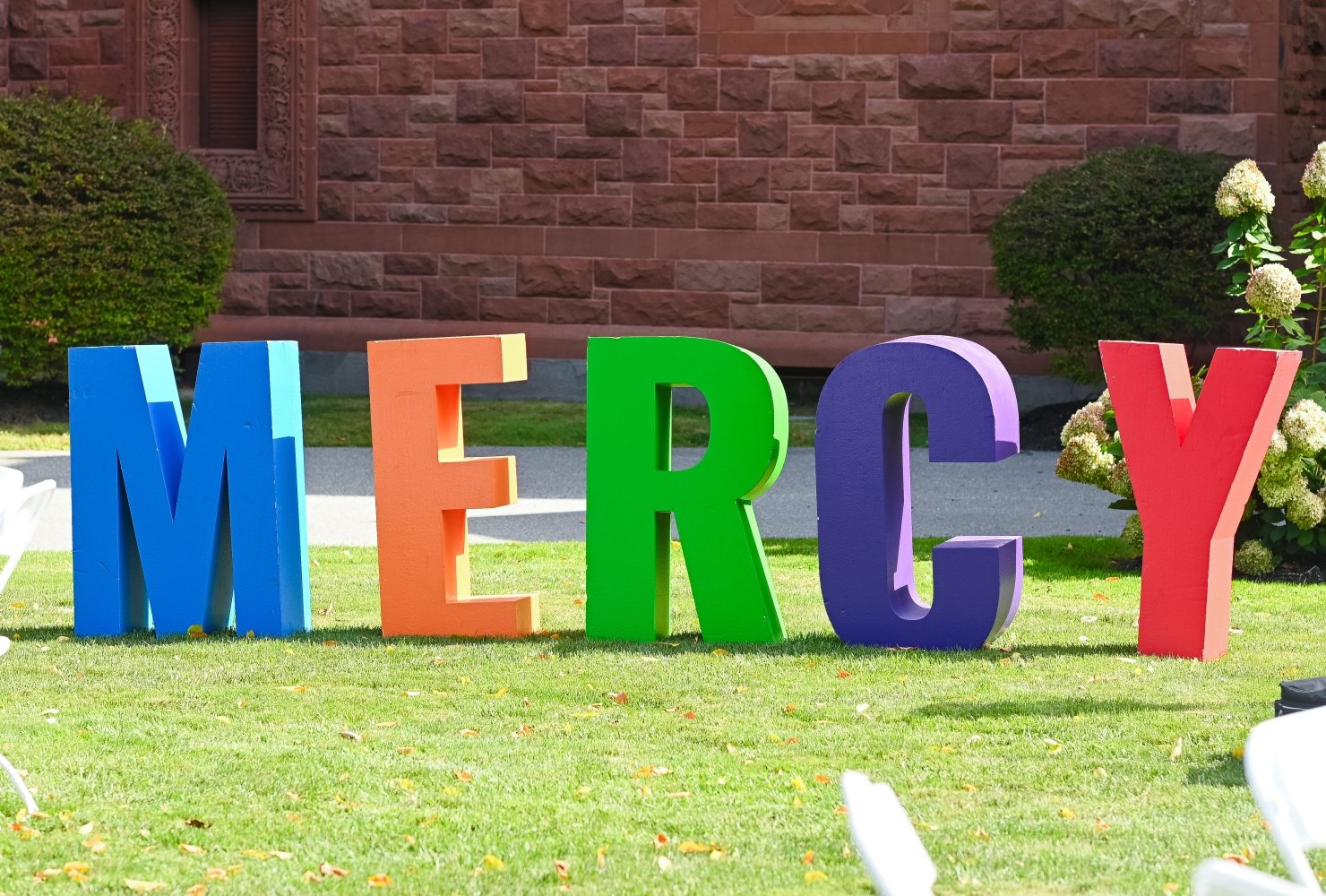 Large colorful letters that spell out 'MERCY' on the lawn.