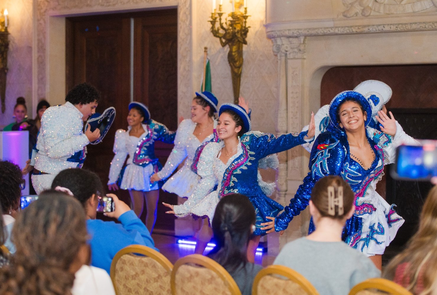Dancers in sparkly blue and white outfits dancing in Ochre Court.