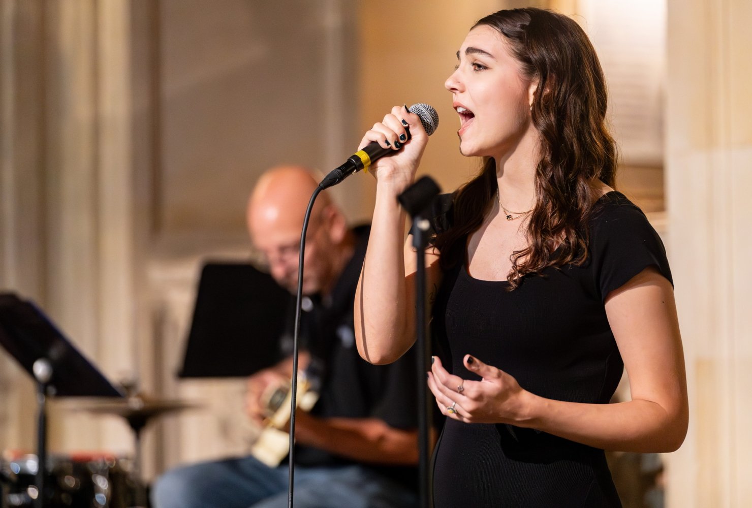 Professional photo of Julia singing into a microphone