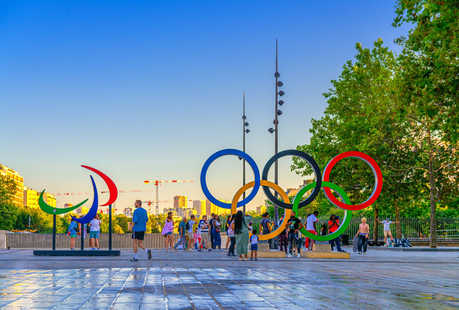 Tourists posing and make photos near Olympic Rings installation on Place de la Bastille square during Olympic Games Paris 2024.