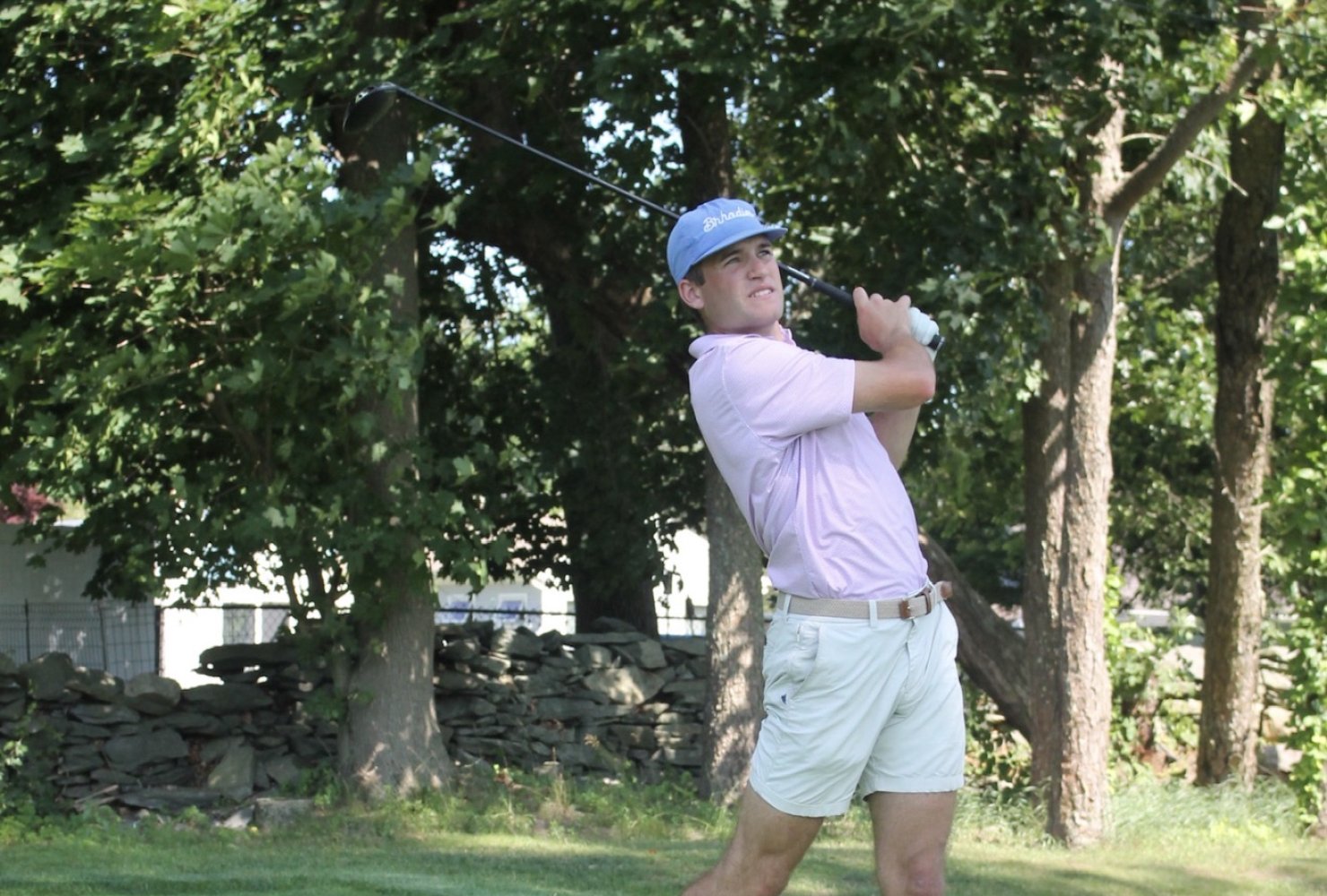 Jack swinging a golf club on the green.