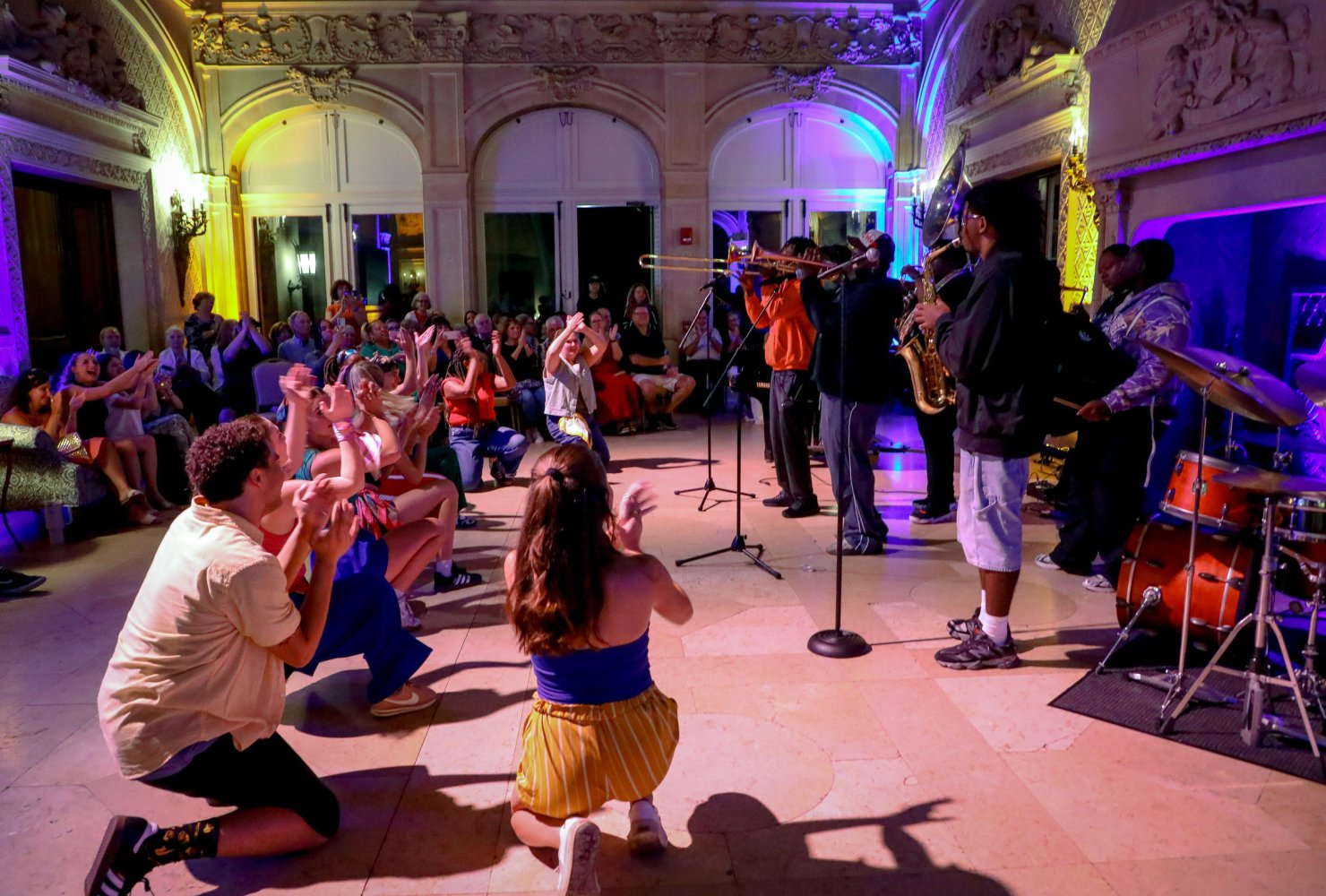 Jazz musicians and dancers perform in a lounge setting in a great hall