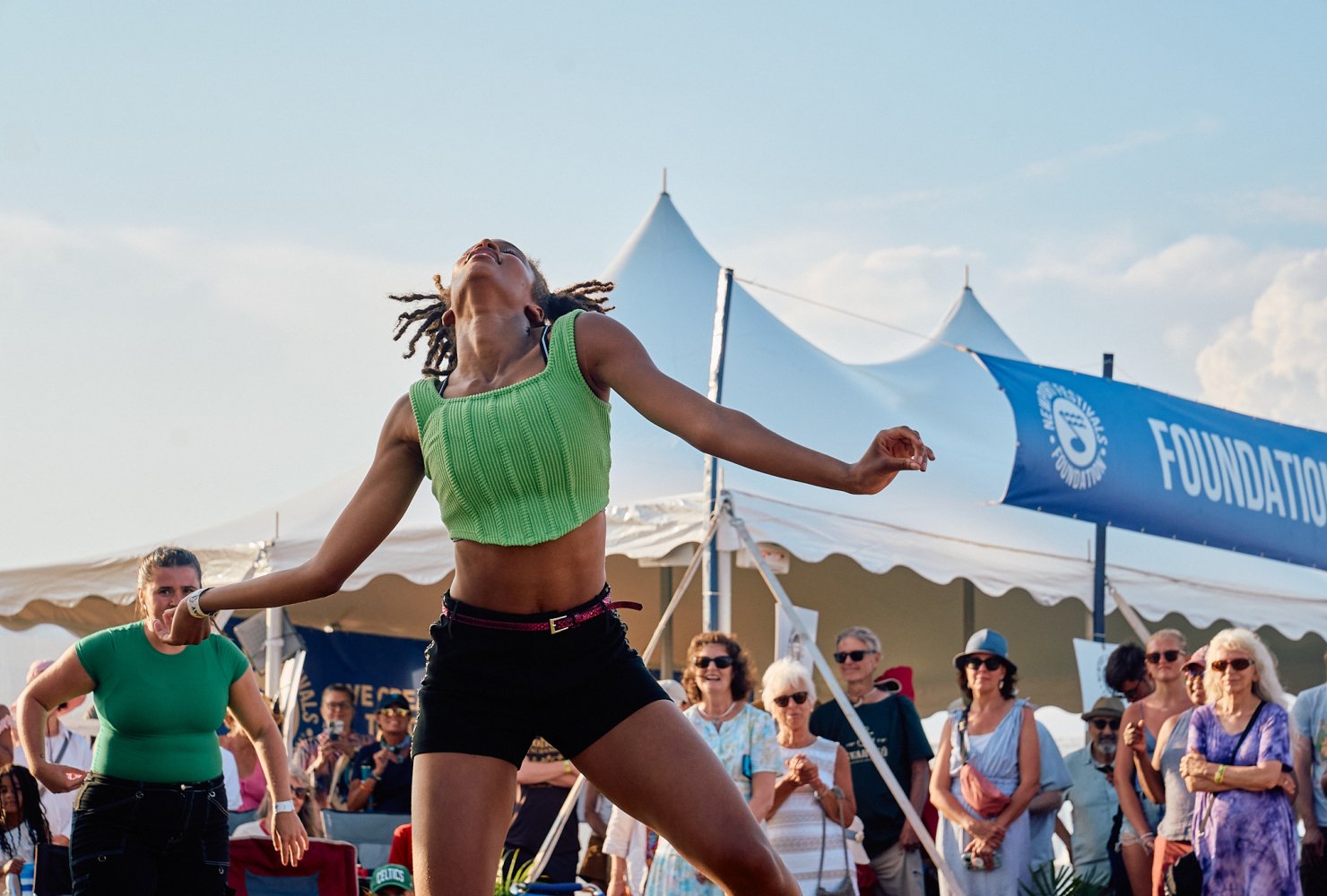 Young woman dancing outdoors in front of a group of dancers