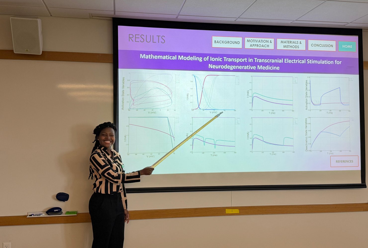 Gloria holding a pointer in front of presentation.