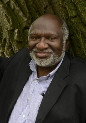Headshot of Charles Coe leaning against the trunk of a tree