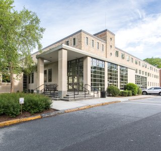 A large square building with a wall of windows on one side