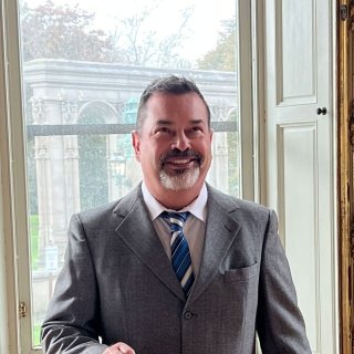 Jerry Krieger smiling, leaning against a podium in Ochre Court
