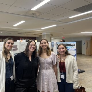 Group photo of students and professor in front of posterboard.
