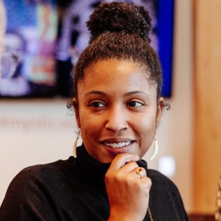 Scholar headshot, smiling, with hand under chin