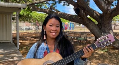 Joy Pye smiling holding a guitar