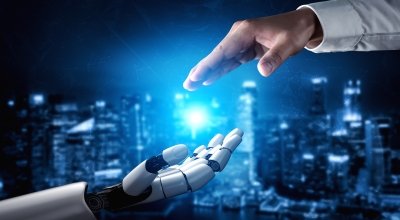 Human hand and robot hand reaching toward each other with futuristic blue background.
