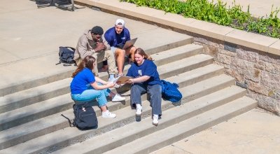 A group of students studying on the back steps of O'Hare.