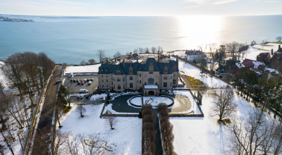 Drone shot of the exterior of Ochre Court in the winter with snow on the ground.