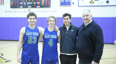 group photo of Brochu family, two in their Salve basketball jerseys, all smiling on the basketball court.