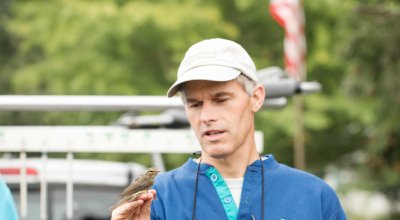 Dr. Jim Chace with a bird perched on his hand.