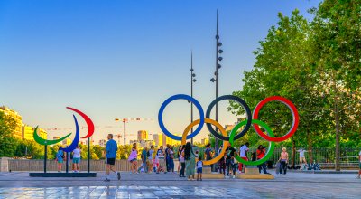 Tourists posing and make photos near Olympic Rings installation on Place de la Bastille square during Olympic Games Paris 2024.