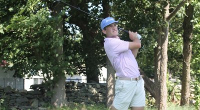 Jack swinging a golf club on the green.