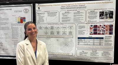 Stirling smiling in front of research poster board.