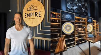Ed Wu in white t-shirt in front of circular Empire logo.