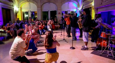 Jazz musicians and dancers perform in a lounge setting in a great hall