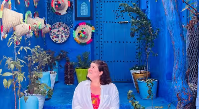 Student sitting in a colorful doorway with Moroccan objects 
