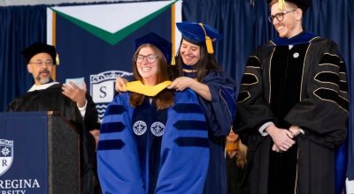 Ph.D. graduate getting academic regalia at commencement