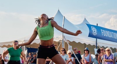 Young woman dancing outdoors in front of a group of dancers