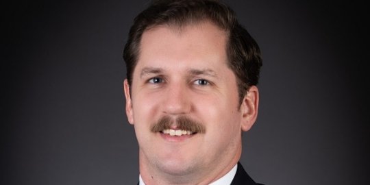 Headshot of alum Terence Nicholas in a suit and tie
