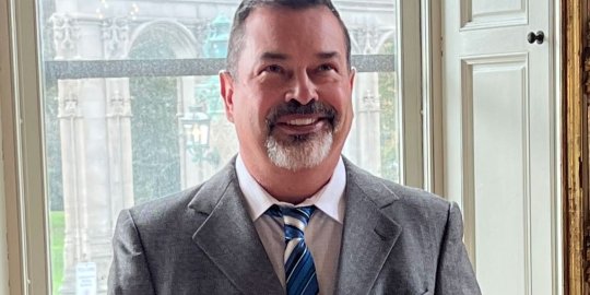 Jerry Krieger smiling, leaning against a podium in Ochre Court