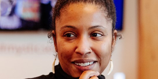 Scholar headshot, smiling, with hand under chin